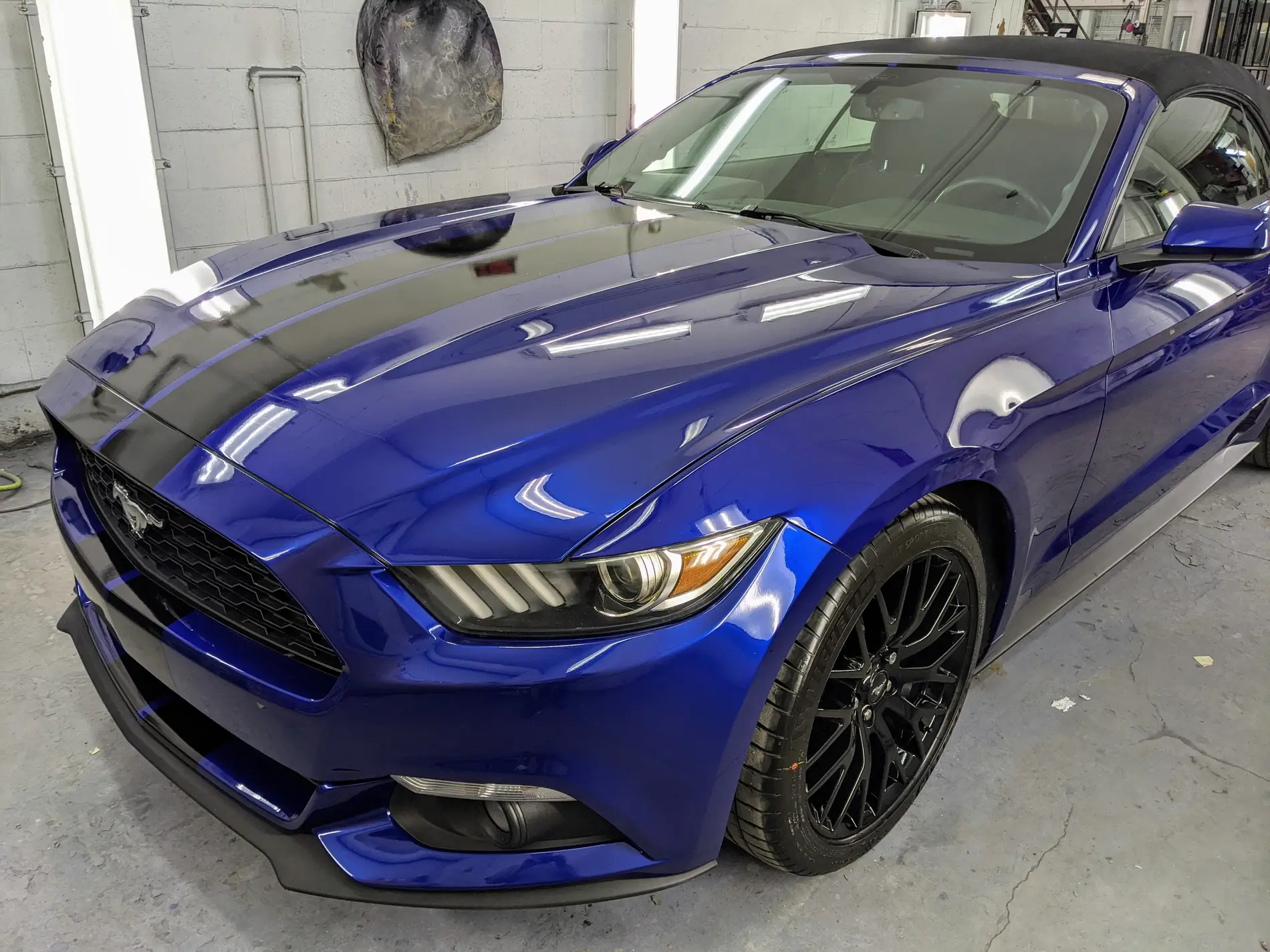 Ford Mustang bleue au capot noir dans l’atelier