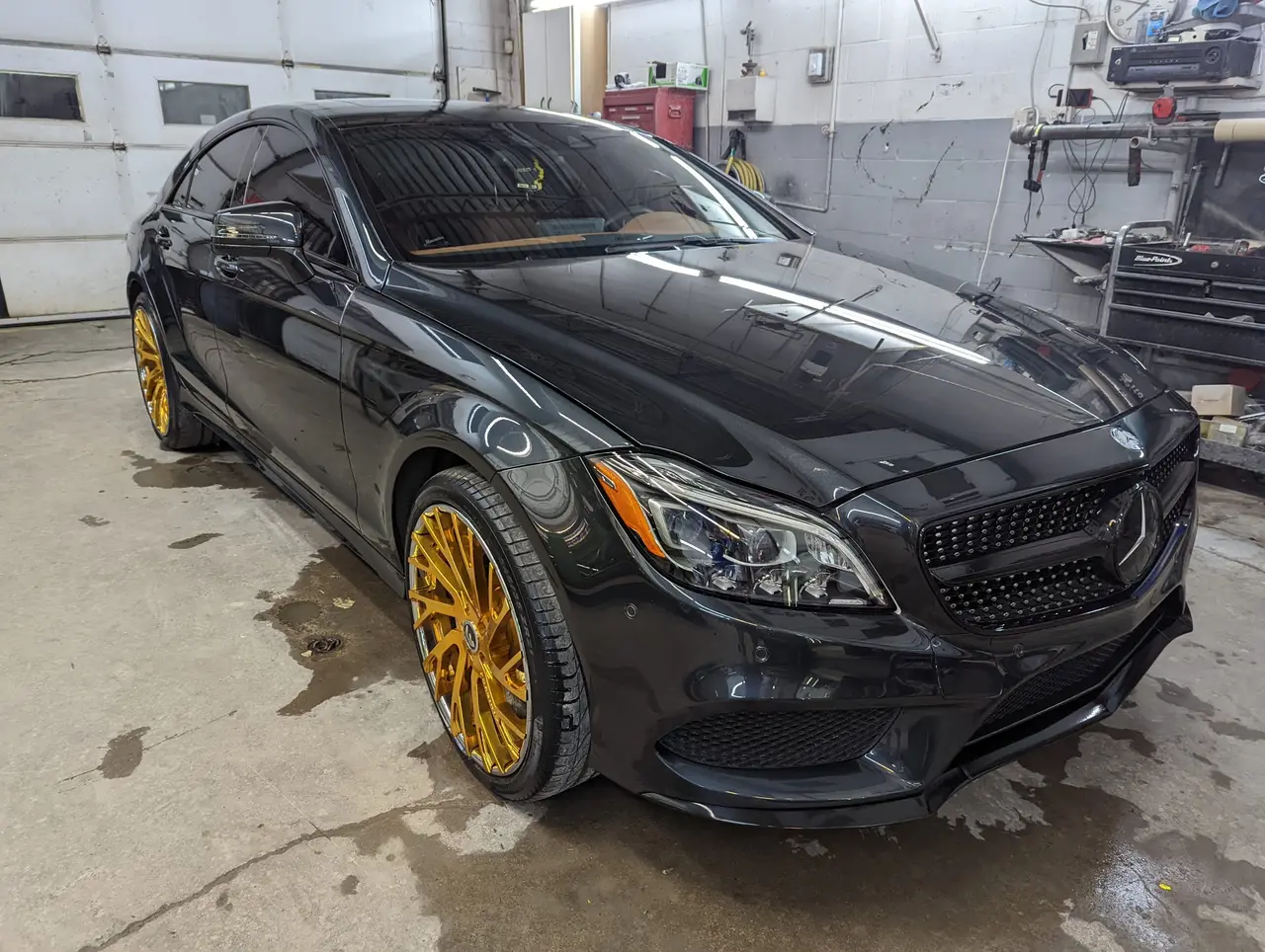 Mercedes-Benz CLS grise avec jantes dorées dans l’atelier