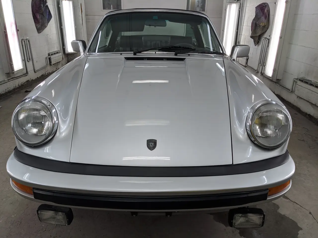 Porsche 911 argentée vue de face, capot et pare-chocs alignés